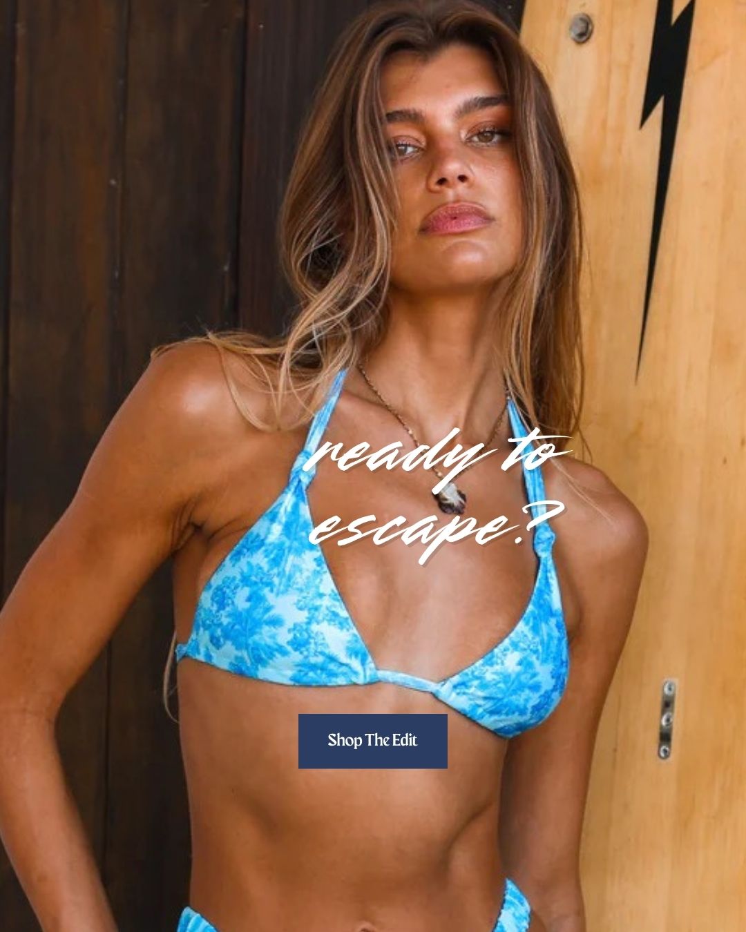 Woman in a blue bikini standing next to a wooden surfboard with text overlay.